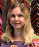 A woman standing in front of some frames.