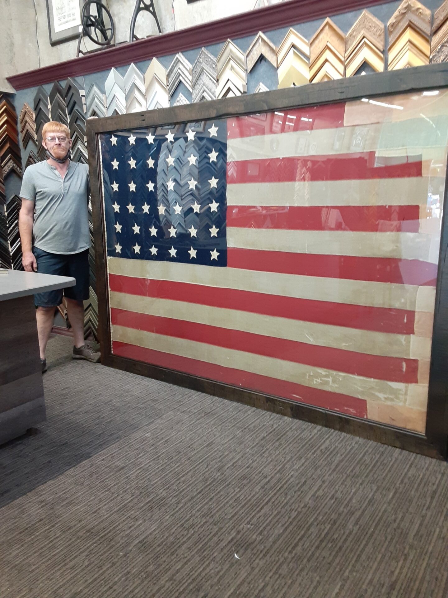 A man standing next to an american flag.