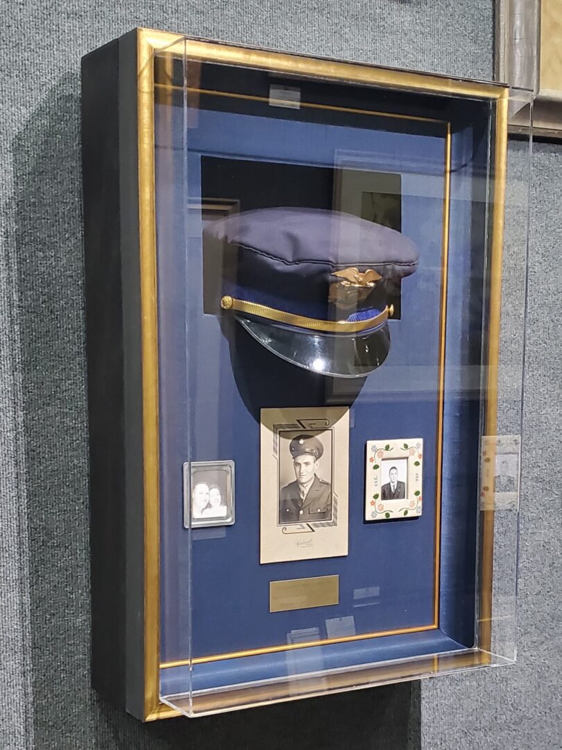 A framed hat case with a picture of a man in uniform.