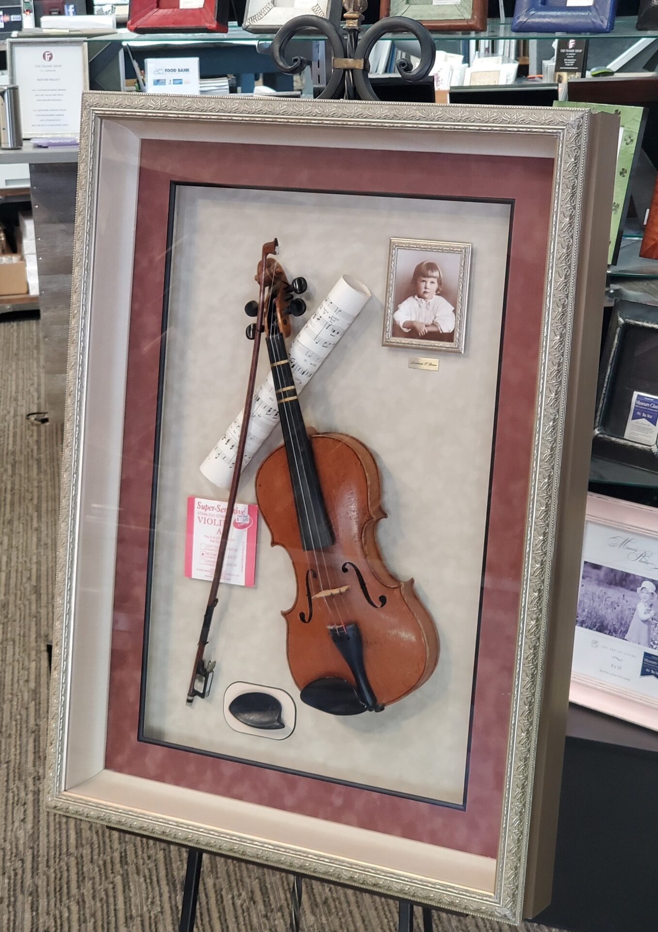 A Violin in a White Frame With Silver Details