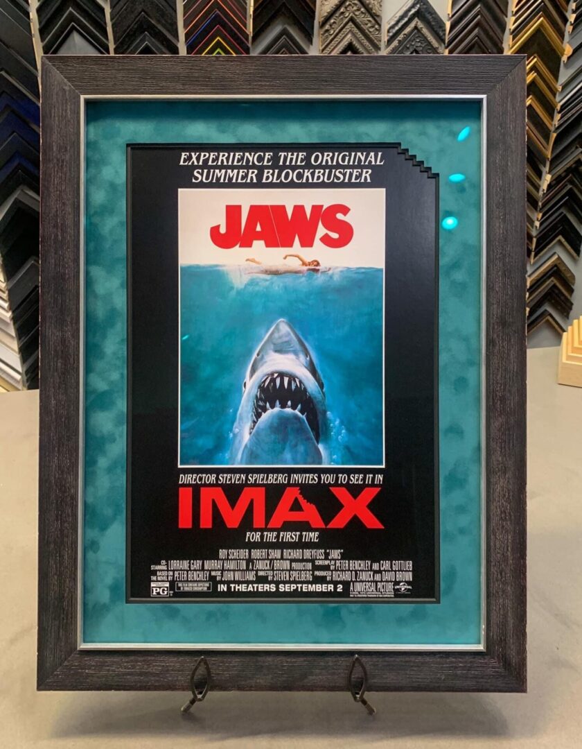 A framed movie poster of jaws