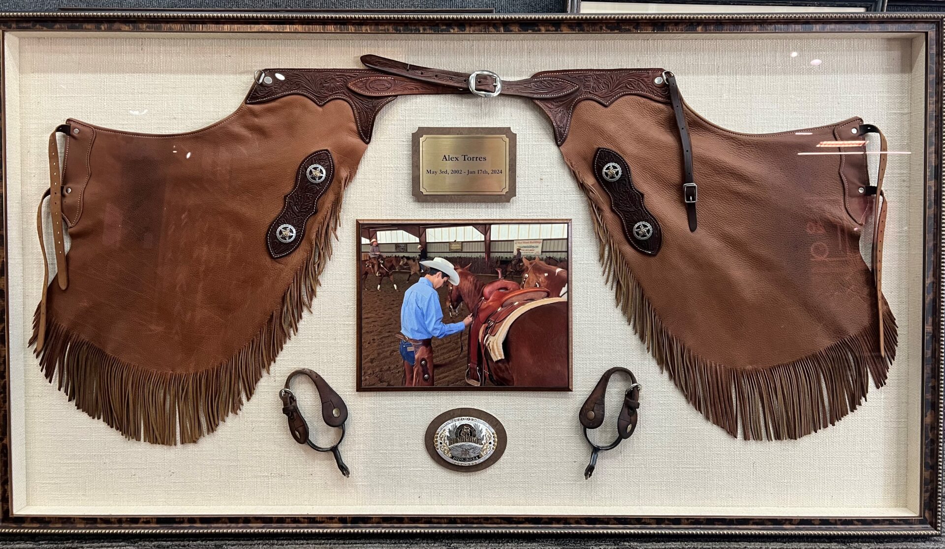 A framed picture of a cowboy and his horse.