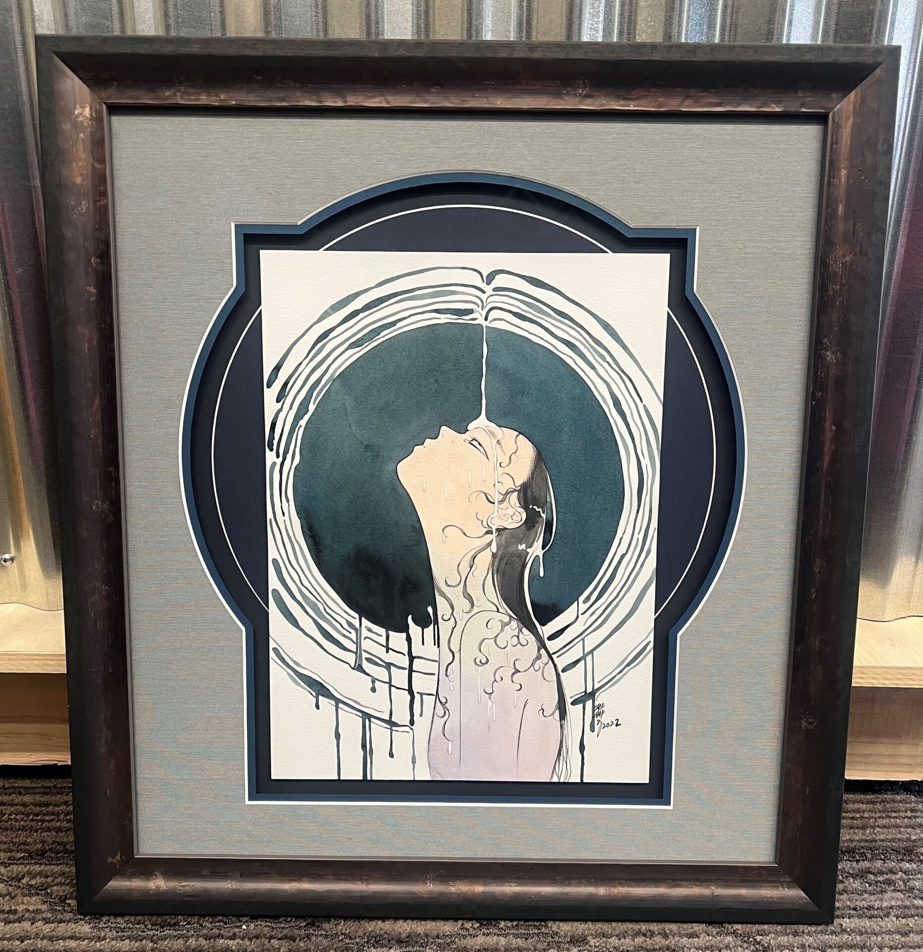 A framed painting of a hand with a circle around it.